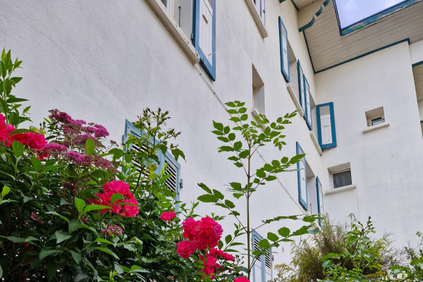 l'Hôtel Les Mésanges située à Saint-Martin-d'Uriage en été, mettant en évidence l'atmosphère accueillante et paisible de l'établissement au cœur d'un cadre naturel enchanteur